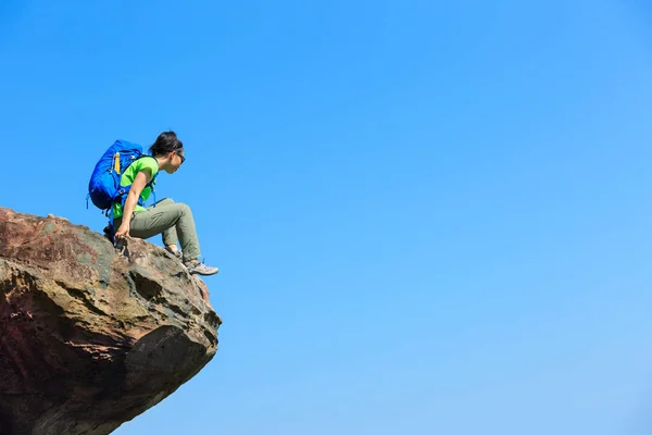 Женщина, сидящая на скале — стоковое фото