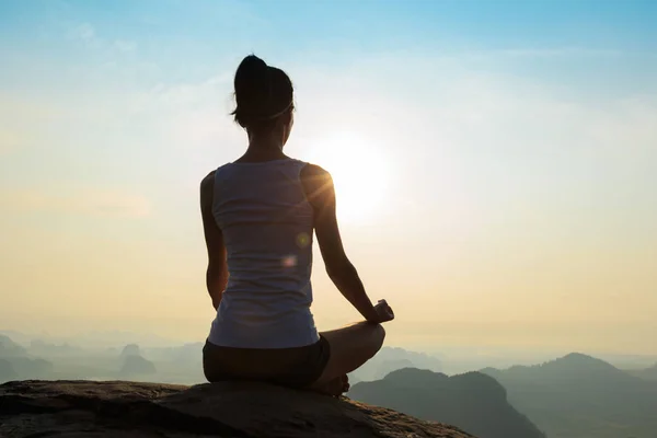 Mujer joven meditando en el pico de la montaña —  Fotos de Stock