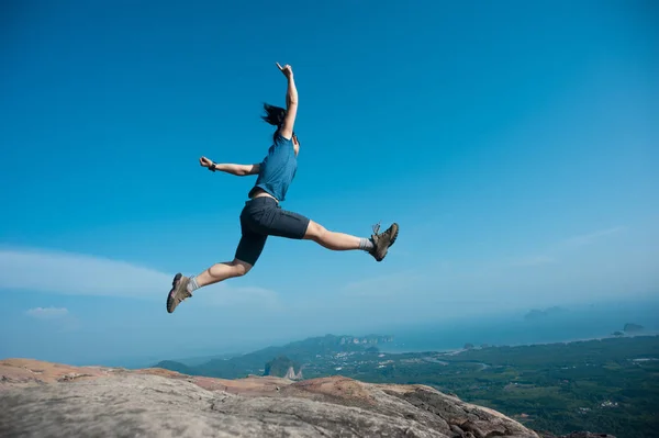 Frau springt auf Berggipfel — Stockfoto