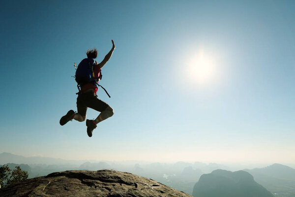woman jumping on mountain 