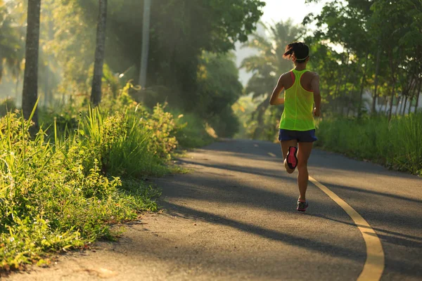 Young woman running on forest trail