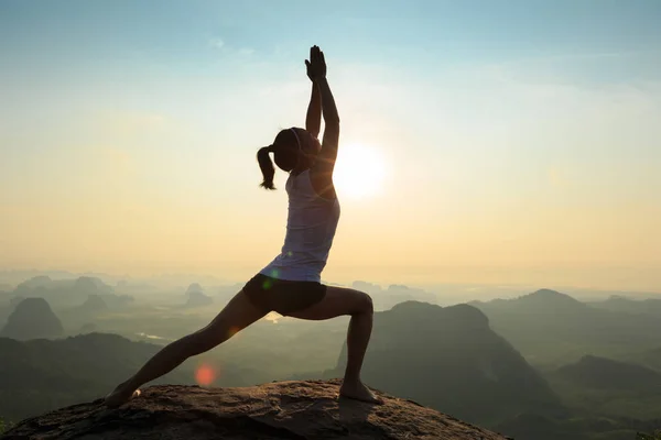 Mujer meditando en el pico de la montaña — Foto de Stock