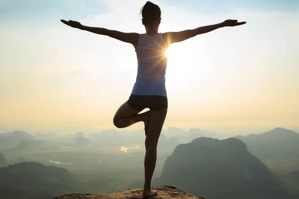 Mujer meditando en el pico de la montaña — Foto de Stock