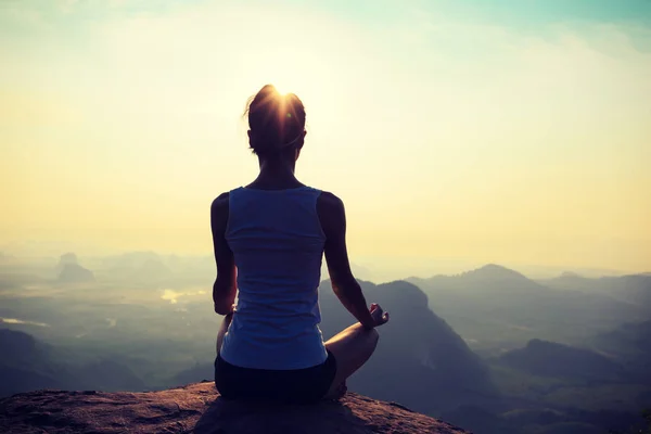 Woman meditating on mountain peak — Stock Photo, Image