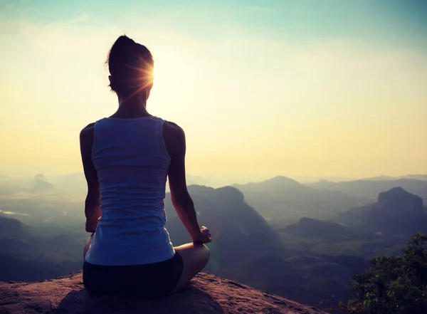 Woman meditating on mountain peak — Stock Photo, Image