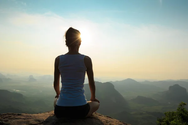 Mujer meditando en el pico de la montaña —  Fotos de Stock