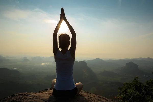 Mujer meditando en el pico de la montaña — Foto de Stock