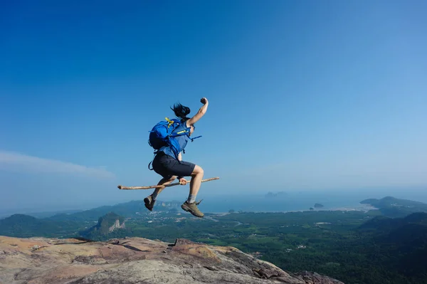 Mulher pulando no pico da montanha — Fotografia de Stock