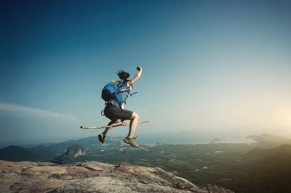 Mujer saltando en pico de montaña — Foto de Stock