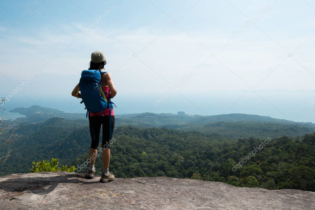 woman enjoying view from mountain peak