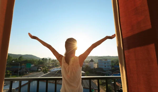 Jonge vrouw staande op het balkon — Stockfoto