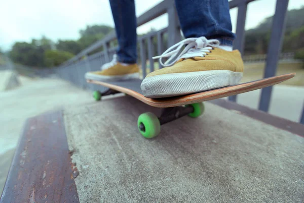 Kvinnliga ben tränar med skateboard — Stockfoto