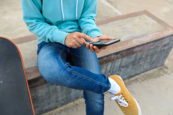 Junge Skateboarder nutzen Smartphone — Stockfoto
