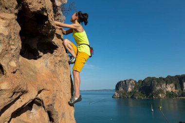 Genç kadın deniz cliff tırmanma 
