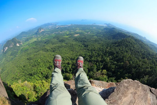 Young woman sitting on mountain cliff