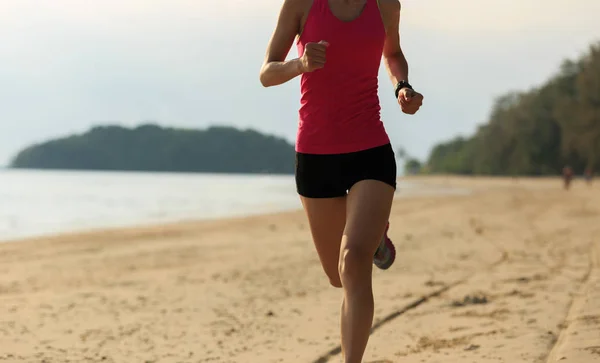 Mujer joven corriendo en la playa de arena — Foto de Stock