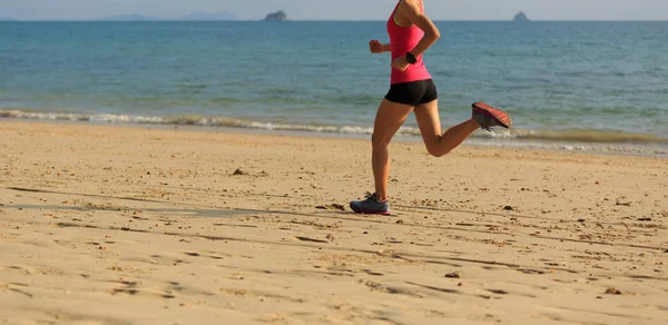 Jonge vrouw actief aan zandstrand — Stockfoto