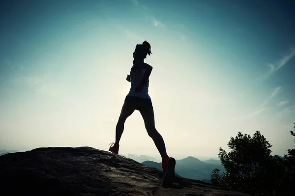 Young woman running on mountain peak — Stock Photo, Image
