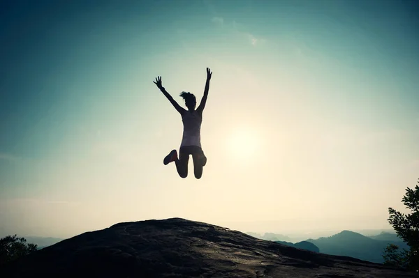 Giovane donna che salta sulla vetta della montagna — Foto Stock