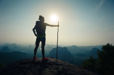 dağın tepesinde duran kadın backpacker
