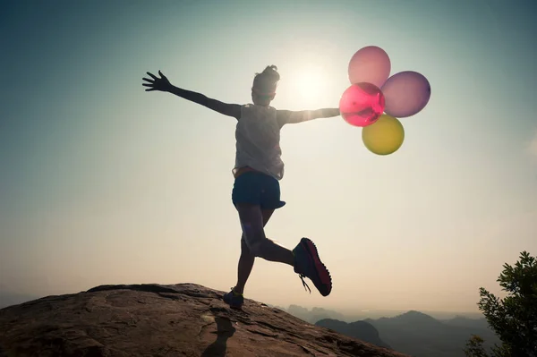 Junge Frau läuft mit Luftballons — Stockfoto