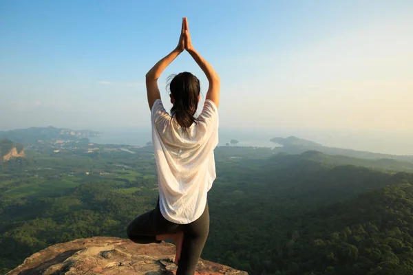 Mujer meditando en el pico de la montaña —  Fotos de Stock