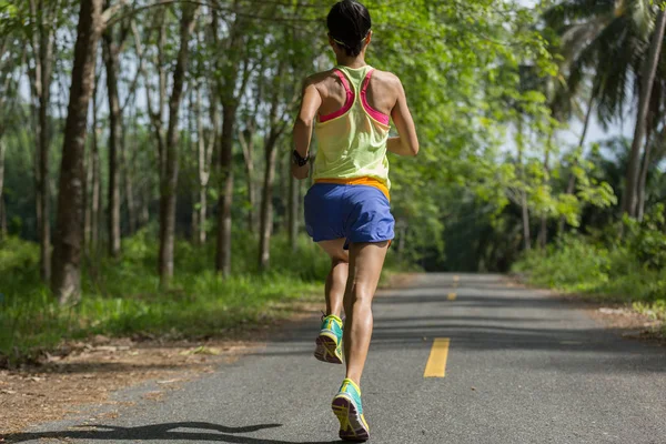 Mujer corriendo por sendero forestal —  Fotos de Stock
