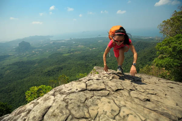 Jovem mulher escalando no topo da montanha — Fotografia de Stock