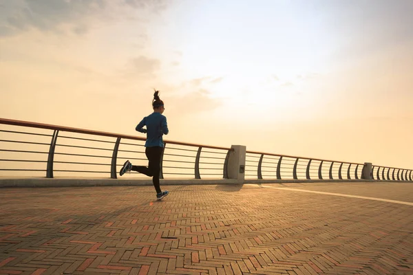 Jonge vrouw rennend aan zee — Stockfoto