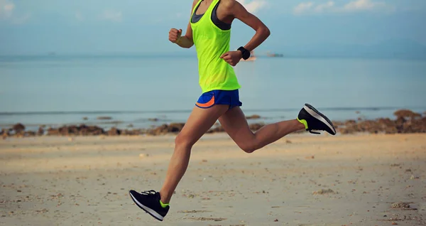 Mujer joven corriendo en la playa de arena — Foto de Stock