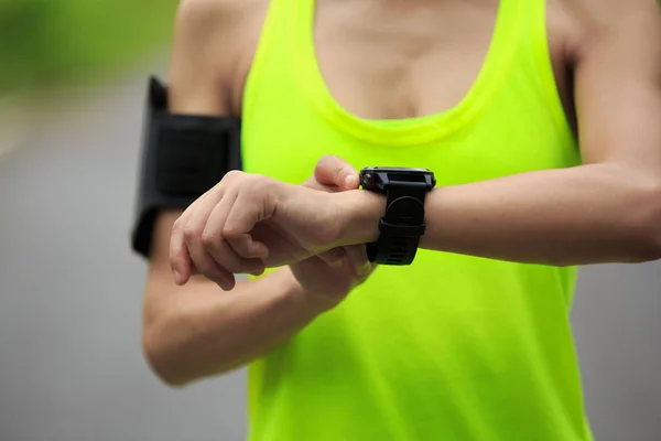 Jeune femme réglage montre de sport — Photo