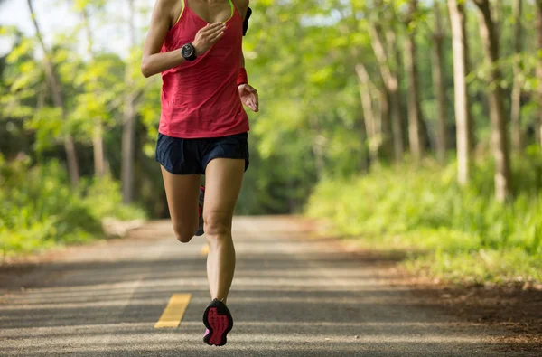 Young woman running on forest trail — Stock Photo, Image