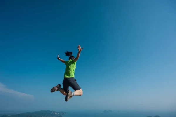 Ung kvinna hoppa på bergstopp — Stockfoto