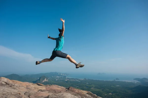 Ung kvinna hoppa på bergstopp — Stockfoto