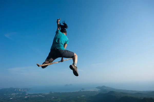 Mujer joven saltando en el pico de la montaña — Foto de Stock