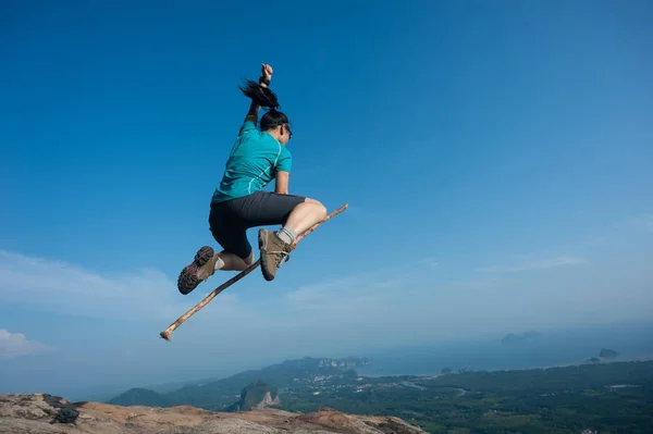 Mujer joven saltando en el pico de la montaña —  Fotos de Stock