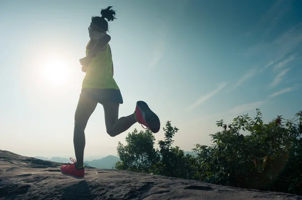 Jovem mulher correndo no pico da montanha — Fotografia de Stock