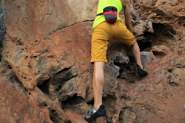 Jovem mulher escalando no penhasco à beira-mar — Fotografia de Stock