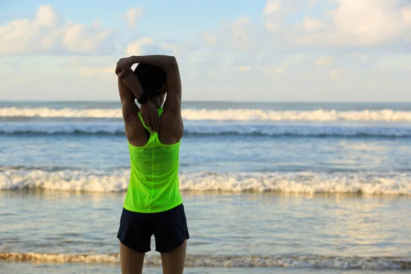 Young woman stretching arms before running — Stock Photo, Image