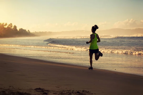 Młoda kobieta działa na piaszczystej plaży — Zdjęcie stockowe