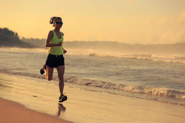 Młoda kobieta działa na piaszczystej plaży — Zdjęcie stockowe