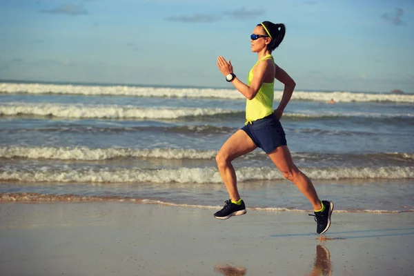 Young woman running on sandy beach — Stock Photo, Image