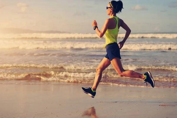 Mujer joven corriendo en la playa de arena — Foto de Stock