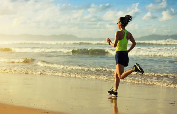 Mujer joven corriendo en la playa de arena — Foto de Stock