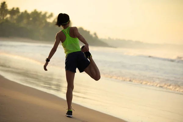 Mujer joven estirando las piernas antes de correr — Foto de Stock