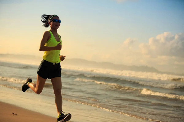 Женщина бегает по песчаному пляжу — стоковое фото