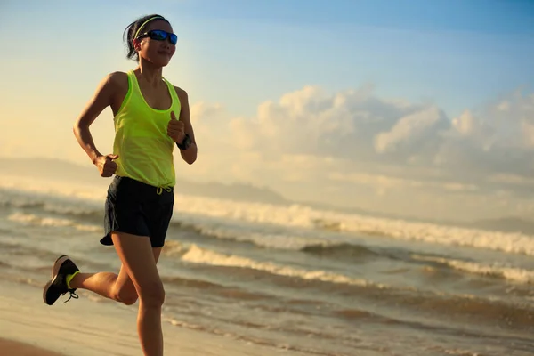 Young woman running on sandy beach — Stock Photo, Image