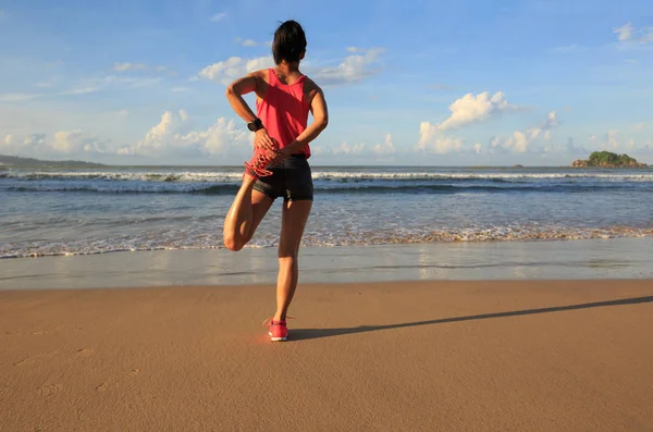 Mujer joven estiramiento piernas — Foto de Stock