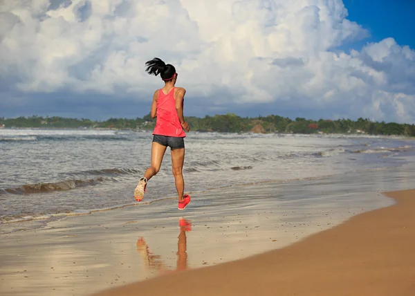 Giovane donna che corre sulla spiaggia — Foto Stock