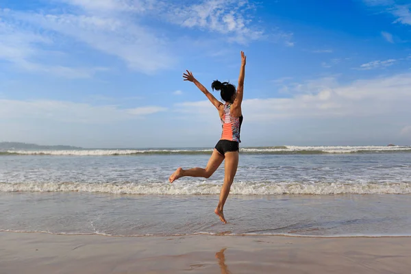 Giovane donna che salta sulla spiaggia — Foto Stock